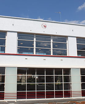 Horloge rouge sur la façade d'un bâtiment blanc