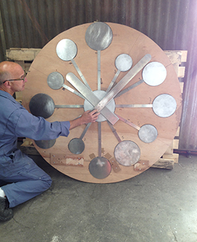 Un ouvrier touchant une aiguille de l'horloge dans un atelier